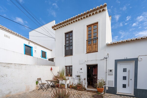 A white building with a tiled roof, a door, and windows.