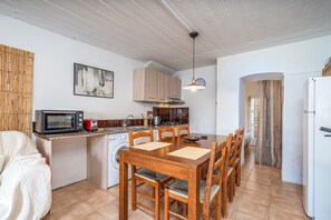 A compact kitchen with a microwave, toaster, sink, and wooden cabinets.