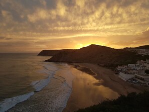 Un paisaje costero con playa, montaña y edificios.