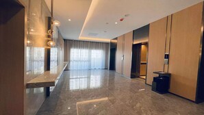 A modern hotel lobby with a marble floor, large windows with sheer curtains, and a reception desk. - Holiday Inn Express Changsha University Tech City by IHG (Changsha)