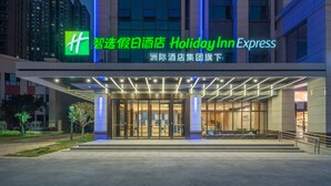 The exterior of a Holiday Inn Express hotel with a modern entrance and illuminated signage. - Holiday Inn Express Changsha University Tech City by IHG (Changsha)