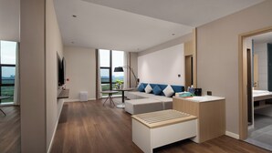 A modern living room with a sofa, coffee table, and a small side table. There is a large window providing a view of the outdoors. - Holiday Inn Express Changsha University Tech City by IHG (Changsha)