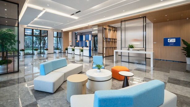 A modern lobby with seating areas, a reception desk, and a large window providing a view of the outdoors. - Holiday Inn Express Changsha University Tech City by IHG (Changsha)