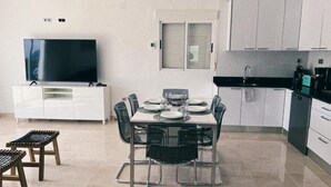 Eine moderne Küche mit weißen Schränken, einer schwarzen Arbeitsplatte und einem eingebauten Ofen.