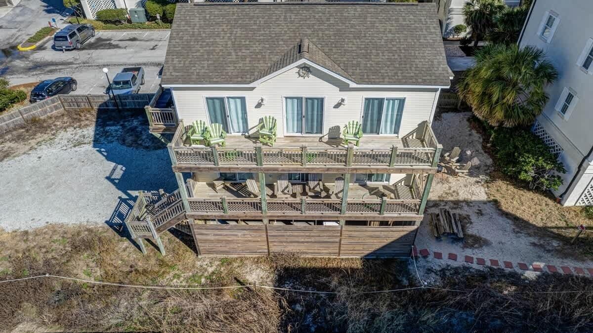 A two-story house with a balcony, a swimming pool, and a fenced deck area.