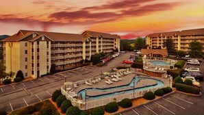 A hotel with multiple floors, a swimming pool, and a parking lot. - FREE Dollywood Ticket • Whispering Pines 143 • 2bd/2ba • City View • Pools (Pigeon Forge)