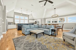 A spacious living area with a sectional sofa, a coffee table, and a dining table with chairs.