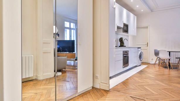 Eine moderne Küche mit weißen Schränken, einem Backofen und einer Mikrowelle.