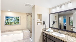 A bathroom with a bathtub, a large mirror, a shower, and a painting on the wall.