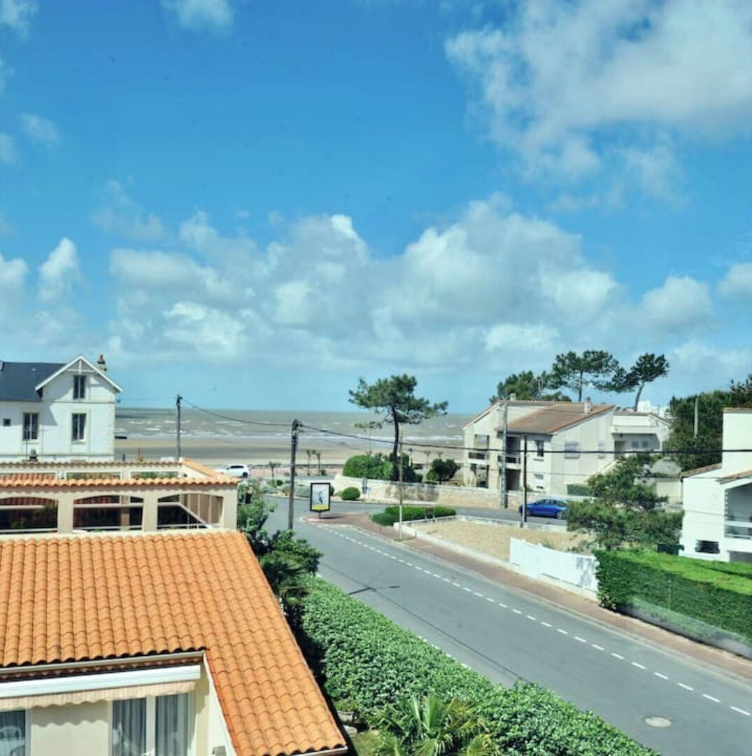 Zona residencial costera con casas, una carretera y cielo despejado.