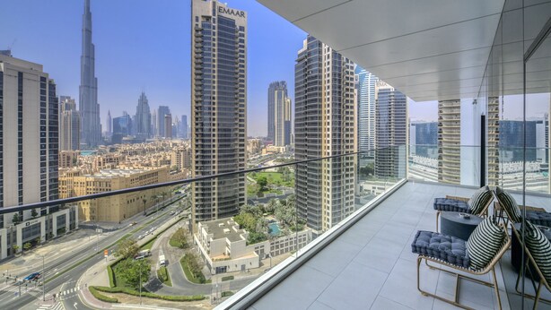 Un balcone con vista sulla città, che include palazzi alti e una strada.