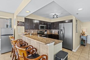 Enjoy cooking in this well-equipped kitchen with a central island, bar stools, and a seating area.