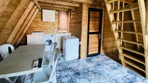 Une cuisine compacte équipée d’un lave-linge, d’un petit réfrigérateur et d’un évier.