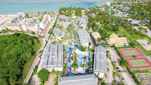 An aerial view of a resort with multiple swimming pools, a tennis court, and lush greenery. - Nannai Residence (Ipojuca)
