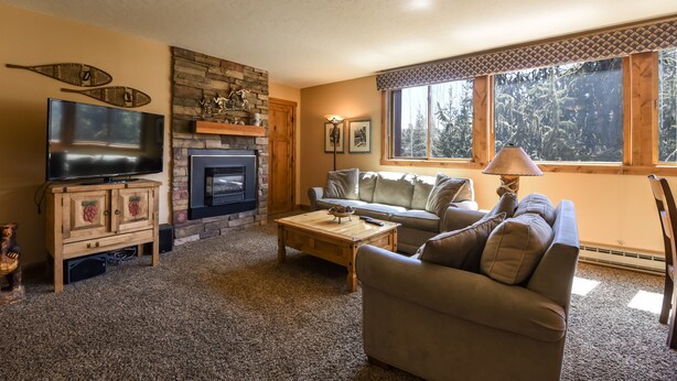 A cozy living room with a fireplace, a television, a sofa, and a coffee table.