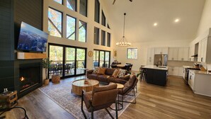 Amplia sala de estar con chimenea, televisor grande y una zona de estar acogedora.