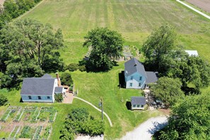 An aerial view of a residential area with two houses, a garden, and a clear sky.