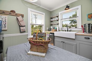 A kitchen with a window, a basket with magazines, and a countertop.