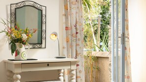 A room with a white desk, a bench, a mirror, a vase with flowers, and a view of greenery outside. - 5* Idyllic rural cottage, only 20 minutes from both North & South Cornish coasts (Truro)