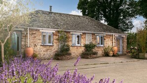 A stone house with a sloped roof, a front door, and a window with a white lattice. - 5* Idyllic rural cottage, only 20 minutes from both North & South Cornish coasts (Truro)