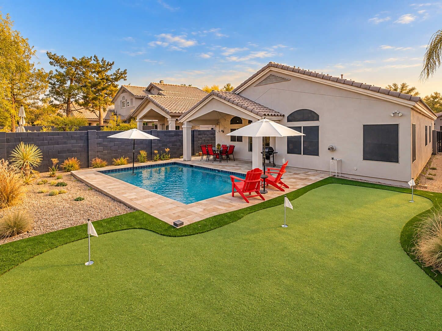 Propiedad residencial con piscina, mobiliario de patio y césped bien cuidado.