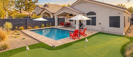 Propiedad residencial con piscina, mobiliario de patio y césped bien cuidado.