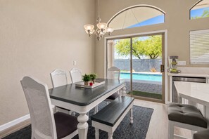 A dining area with a table, chairs, and a chandelier.