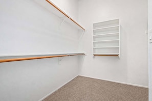 A room with a ballet barre, a white wall, and a carpeted floor.