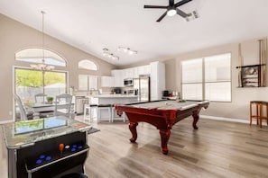 A modern kitchen with white cabinets, a red pool table, and a foosball table. - TPC Scottsdale Retreat|Heated Pool + Putting Green (Scottsdale)