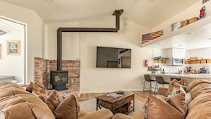 Una sala de estar moderna con chimenea de ladrillo, sofás de cuero y una mesa de centro.