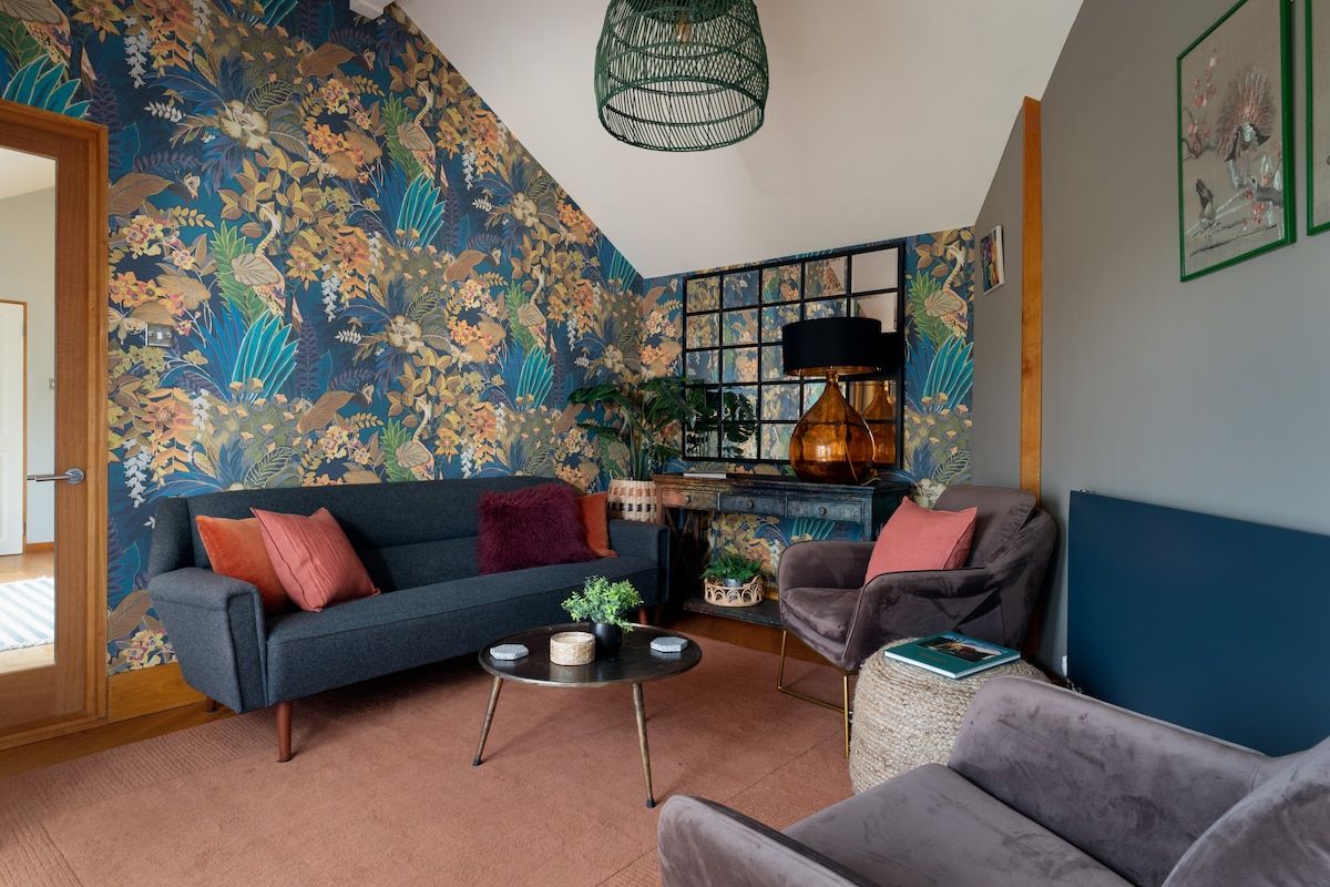 Un salon avec un canapé bleu, une table basse ronde et une lampe décorative.