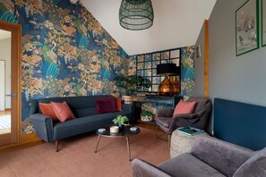 A living room with a blue sofa, a round coffee table, and a decorative lamp.