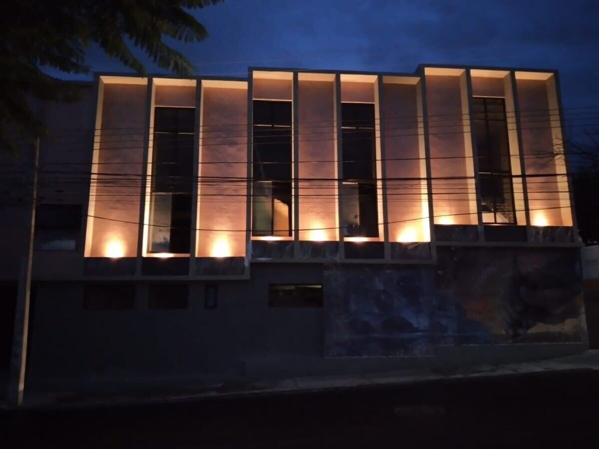 A modern building with illuminated windows and a flat roof.