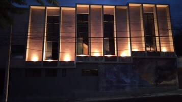 A modern building with illuminated windows and a flat roof.