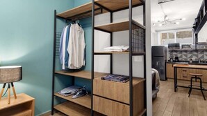 Una habitación pequeña con literas, una kitchenette y un escritorio con lámpara.