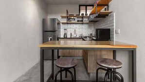 Una cucina moderna con isola centrale, sgabelli da bar, forno integrato e forno a microonde.