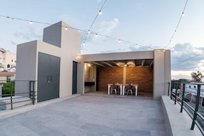 Enjoy al fresco dining on the outdoor terrace, featuring a stylish seating area with a table and chairs.