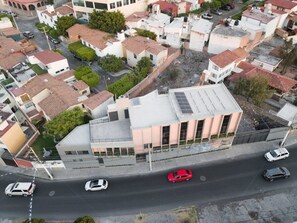 Stylish building with a flat roof and large windows, situated among traditional houses.