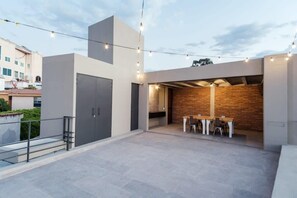 Enjoy al fresco dining and social gatherings in this inviting outdoor space with a minimalist design and brick accent wall.