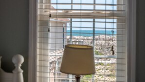 A room with a view of the ocean through a window with blinds. - Skipper's Hideout | Ocean Views + Walk to Beach! (North Topsail Beach)