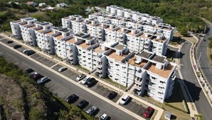 Un edificio de apartamentos de varios pisos con un estacionamiento al frente.
