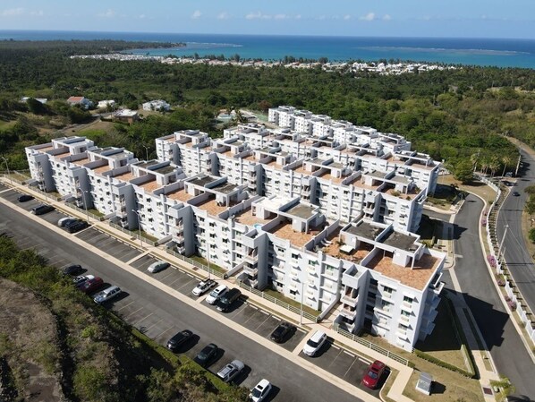 A multi-story residential building with a parking lot in front. - 3 Bedrooms Apt. close to main beaches/ attractions (Río Grande)