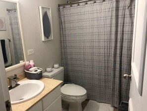 A bathroom with a white sink, toilet, and shower curtain. - 3 Bedrooms Apt. close to main beaches/ attractions (Río Grande)