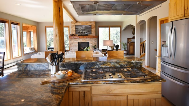 Una cocina amplia con una isla grande, estufa integrada y un refrigerador de acero inoxidable.