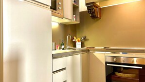 Eine moderne Küche mit Edelstahlgeräten, einem Backofen und einer Spüle mit diversen Küchenutensilien.