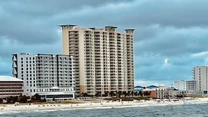 Un hôtel en bord de mer, doté de plusieurs étages, de balcons et offrant une vue sur la plage.