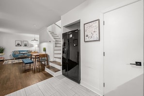 Ein modernes Wohnzimmer mit Sofa, Couchtisch und einer Treppe, die in einen Küchenbereich führt.