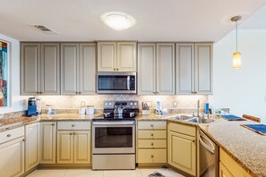 Enjoy cooking in this well-equipped kitchen with a double sink, microwave, oven, and coffee maker.