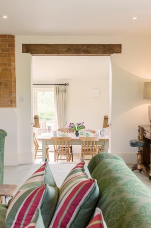Una sala acogedora con un sofá, una mesa de comedor con sillas y una zona de cocina con estufa.