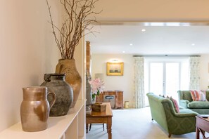 A living room with a sofa, a coffee table, and decorative vases. - Chater Barn (Leicester)
